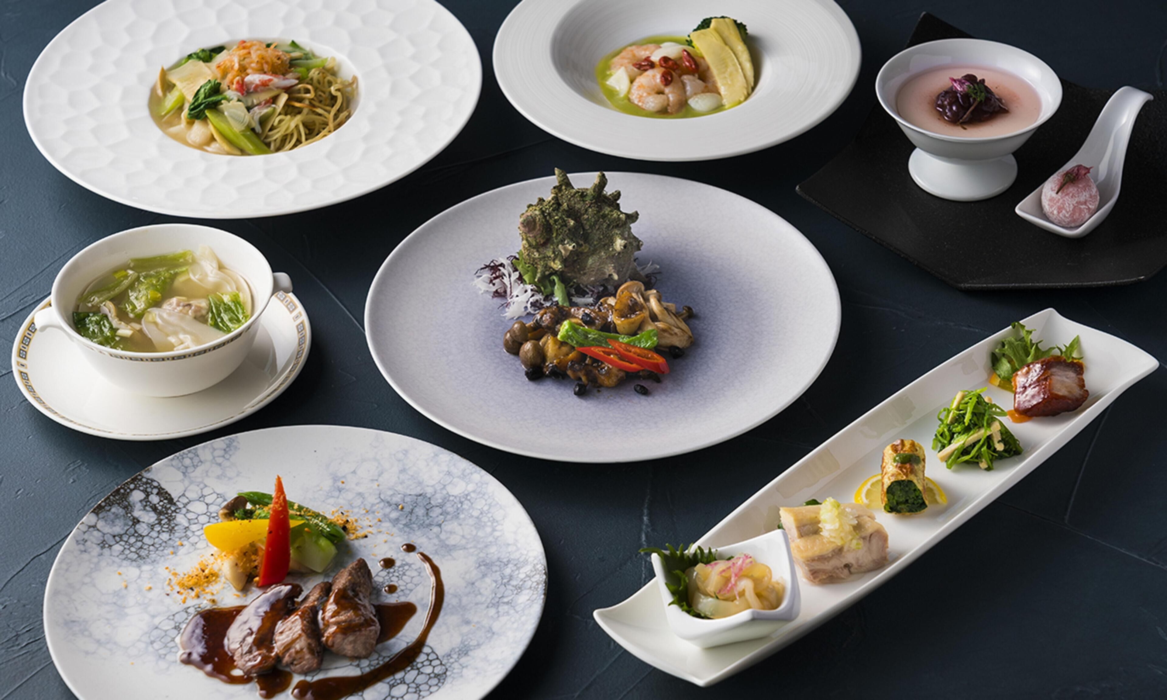 Diverses platillos sobre plats i una llarga safata de servei, indicant una experiència gastronòmica d'alt nivell.