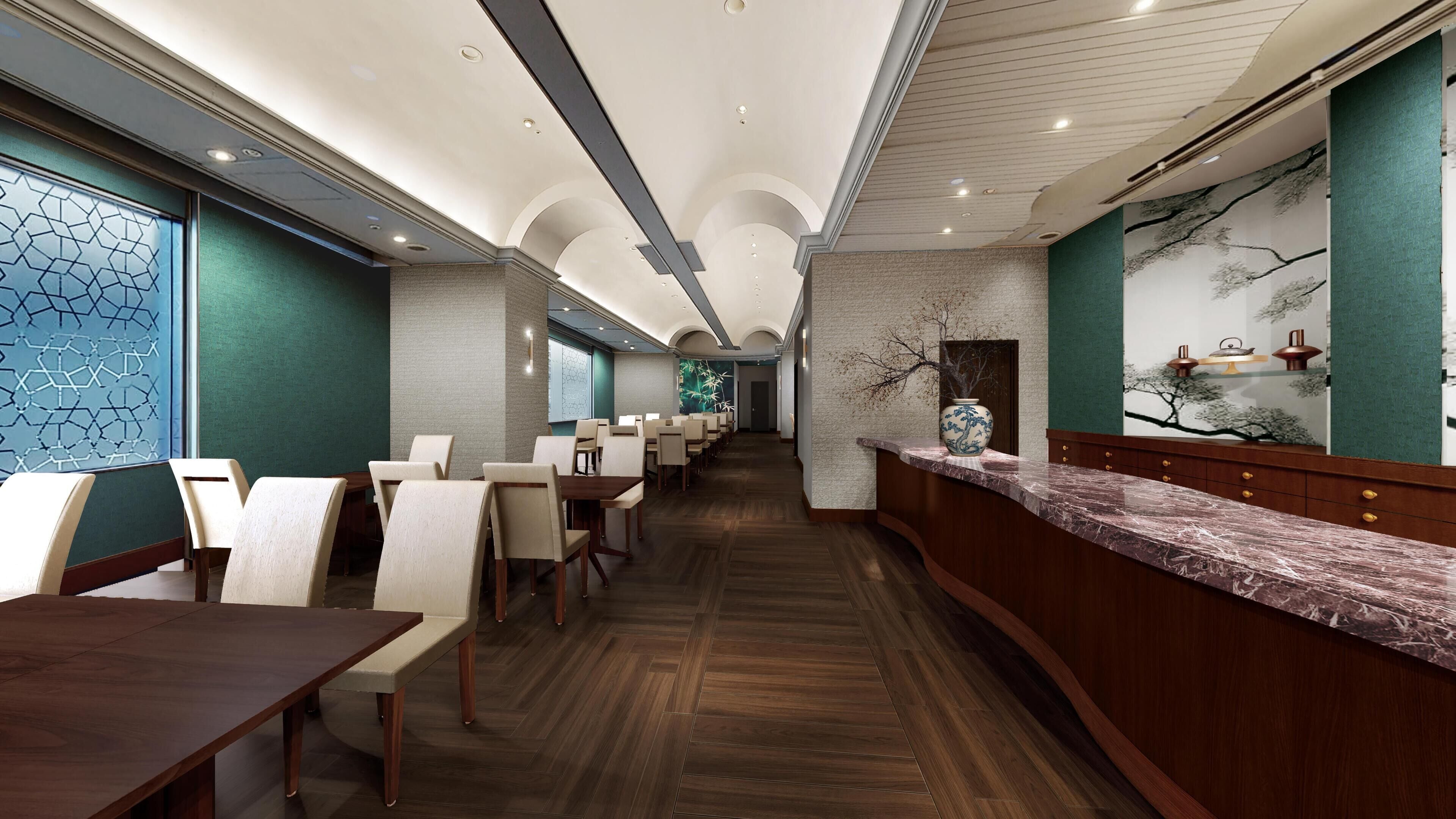 A hotel lobby with a long reception desk, multiple seating areas, and a decorative wall mural.