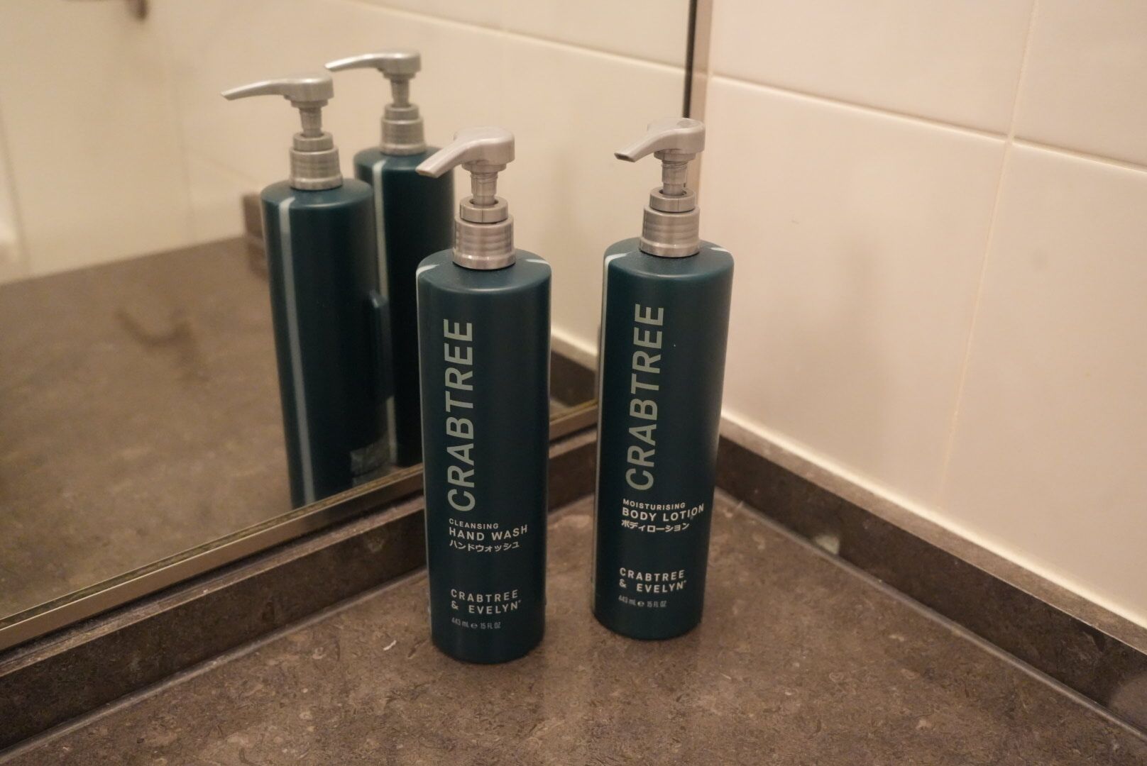 Three bottles of Crabtree hand wash and body lotion on a bathroom counter.