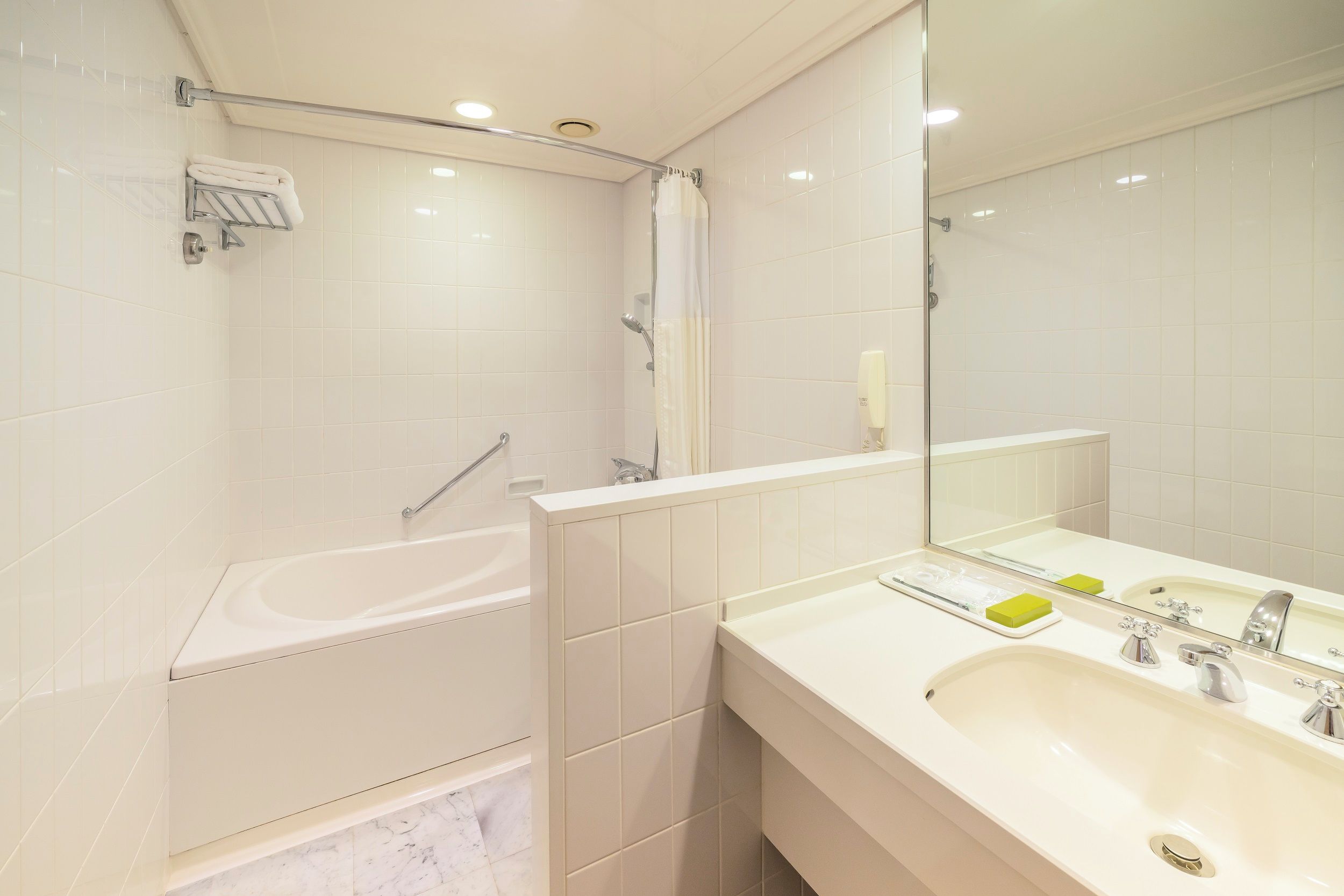 A modern bathroom with a bathtub, a shower, a sink, and a mirror.