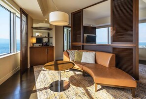 A modern living room with a leather sofa, a round coffee table, and a television on a stand.
