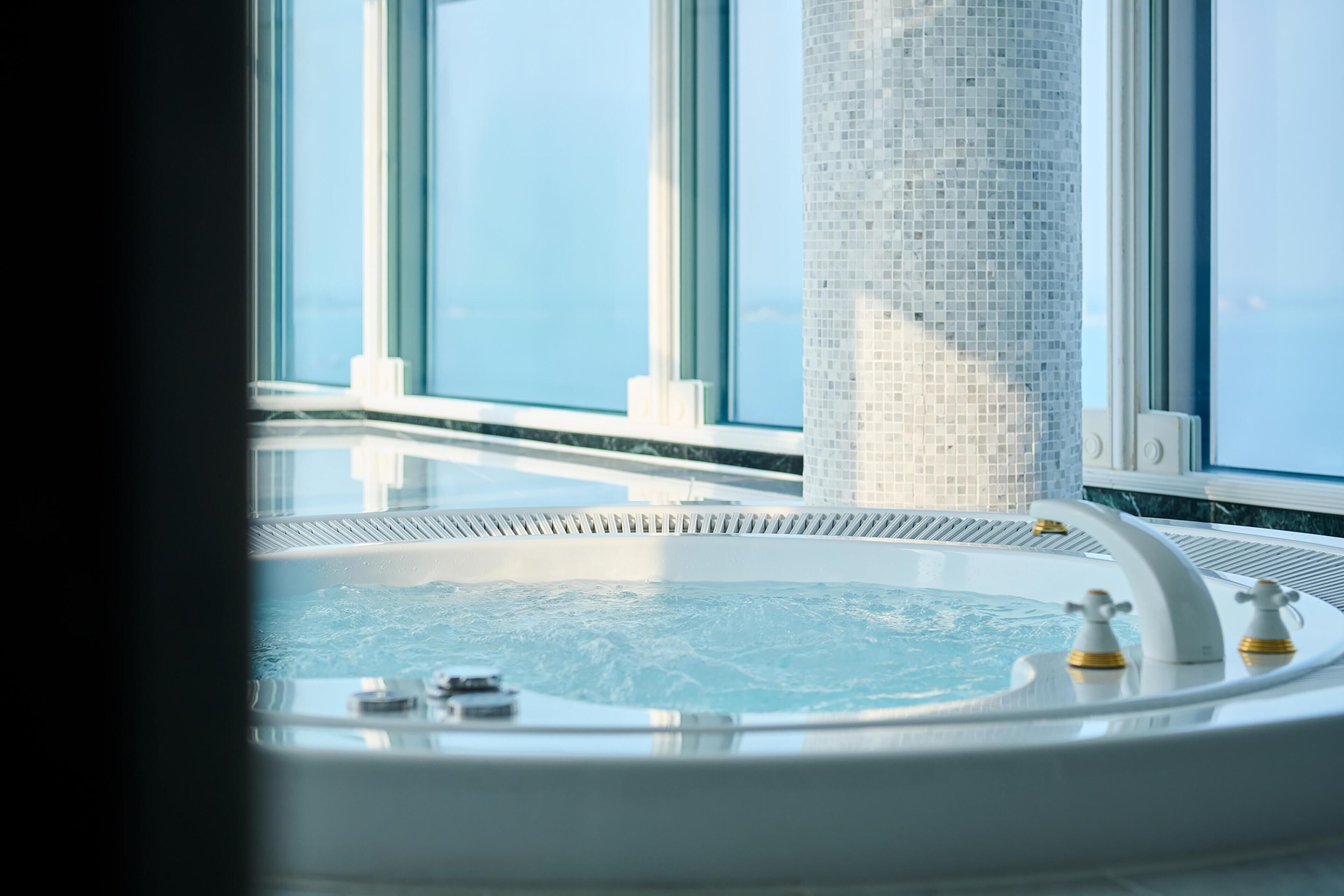 Un jacuzzi con vistas al cielo a través de amplios ventanales.