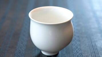 A white ceramic cup on a textured wooden surface.