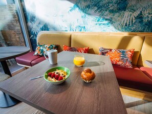 A breakfast setup with a bowl of cereal, a muffin, and a glass of orange juice on a table. - ibis Styles Antibes (Antibes)