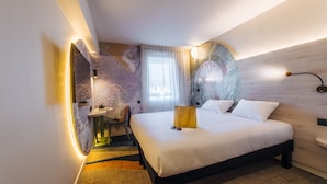 Una habitación de hotel moderna con una cama grande, un escritorio y una silla.