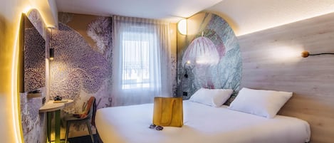 Een hotelkamer met een bed, een stoel, een klein tafeltje en een wand met een uniek ontwerp.