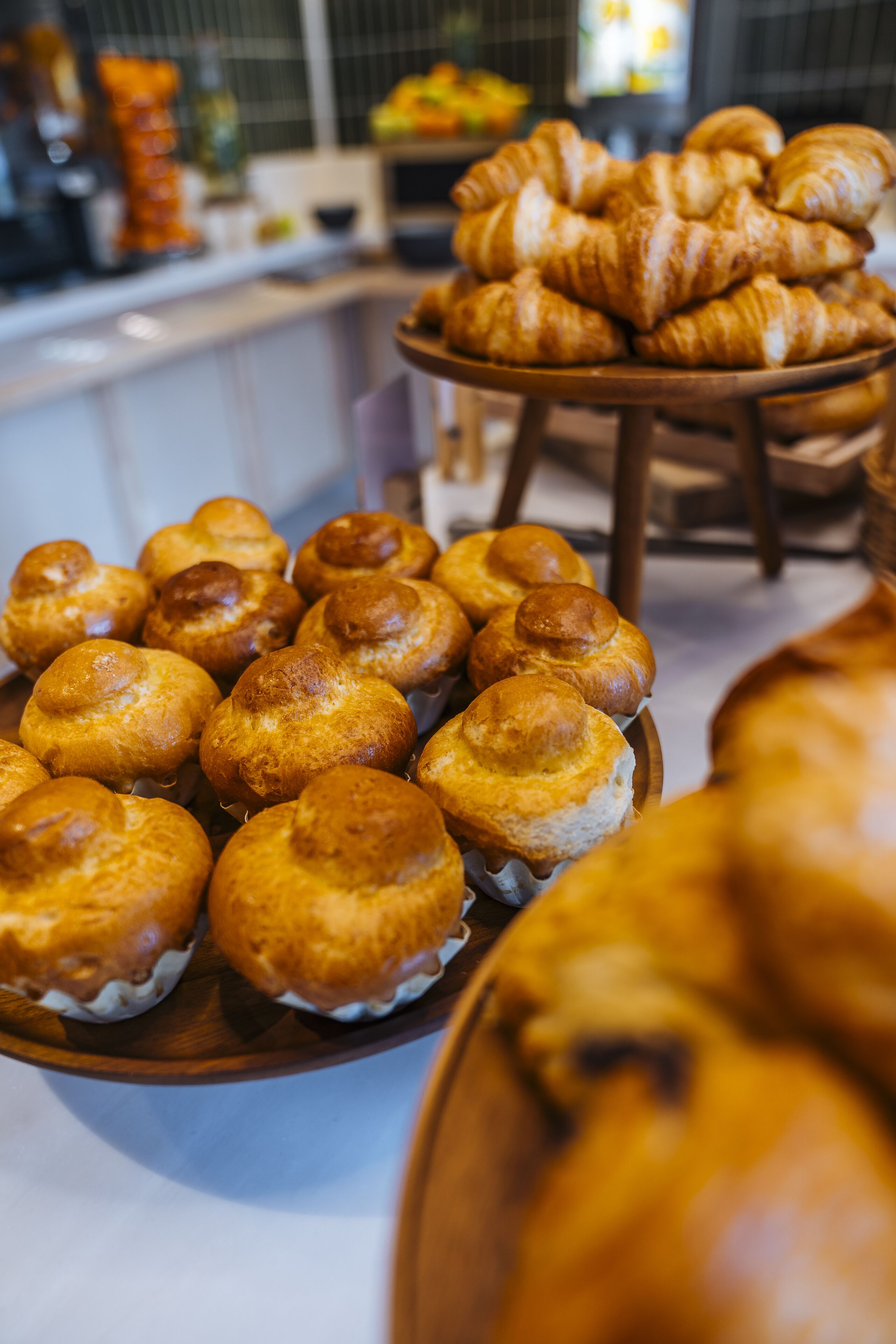 A display of pastries, including croissants and muffins, arranged on a wooden table.