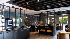 A modern cafe with a central island, seating area, and a coffee machine. - Kyriad - Beaune (Beaune)