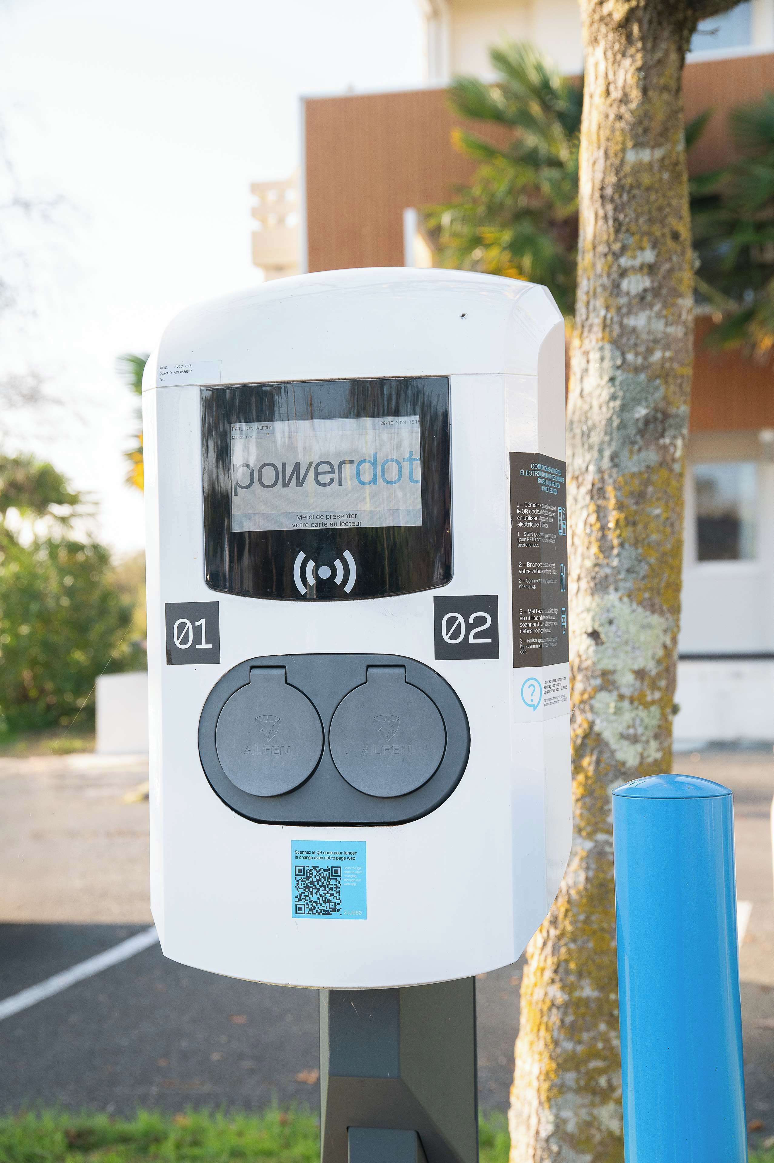 A public charging station with two charging slots, labeled "01" and "02", and a QR code for user interaction.