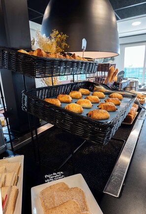 A buffet setup with bread and pastries.
