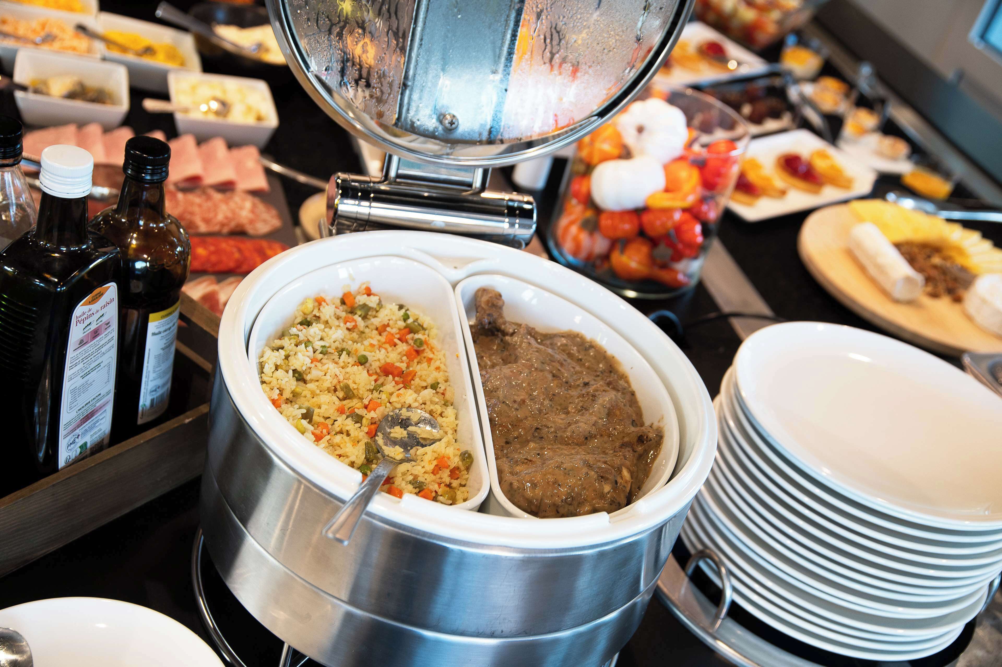 Un bufé con diversos platos, entre ellos arroz, carne y verduras.