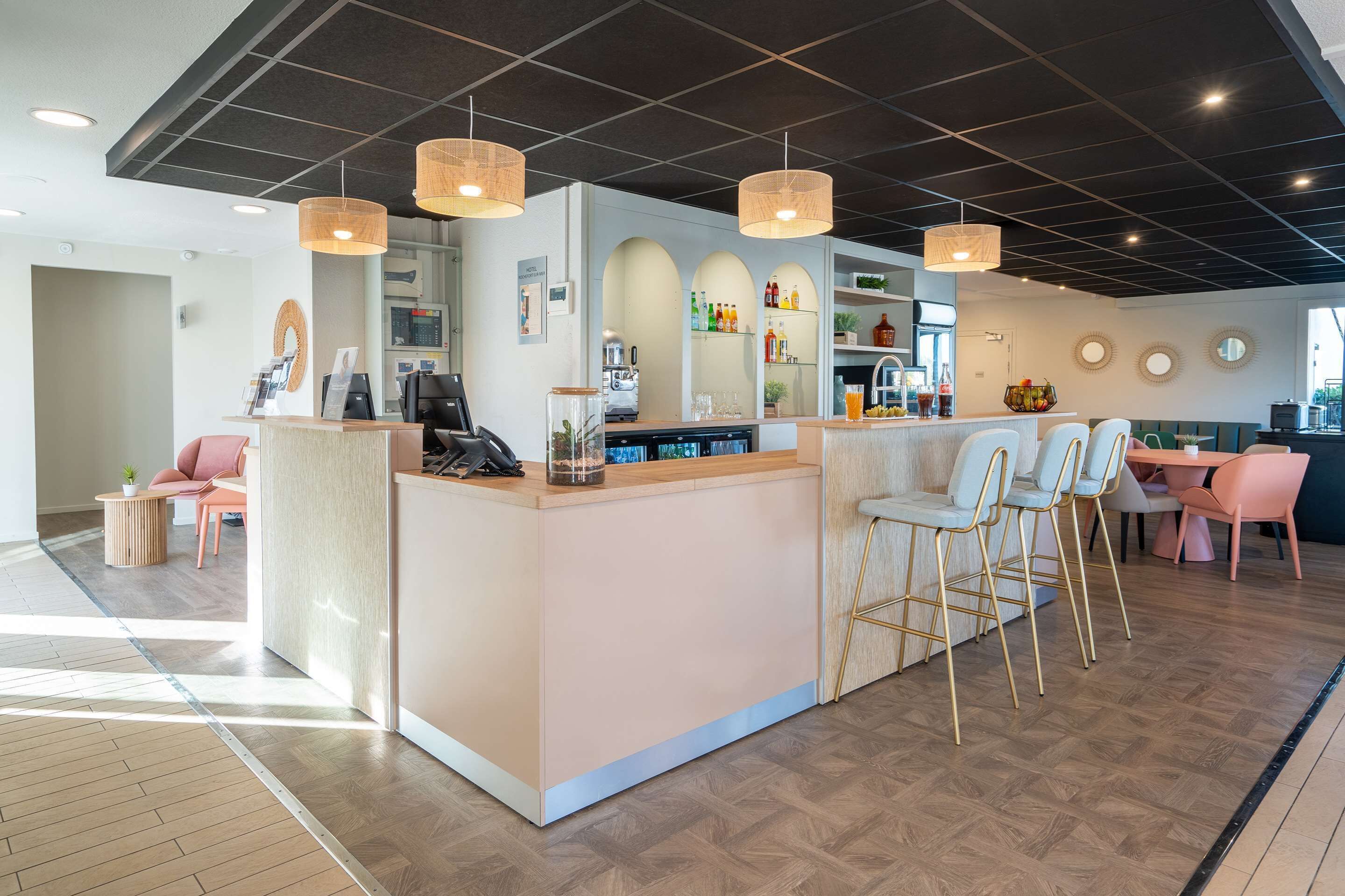 Un área de recepción moderna con mostrador, asientos y una máquina de café.