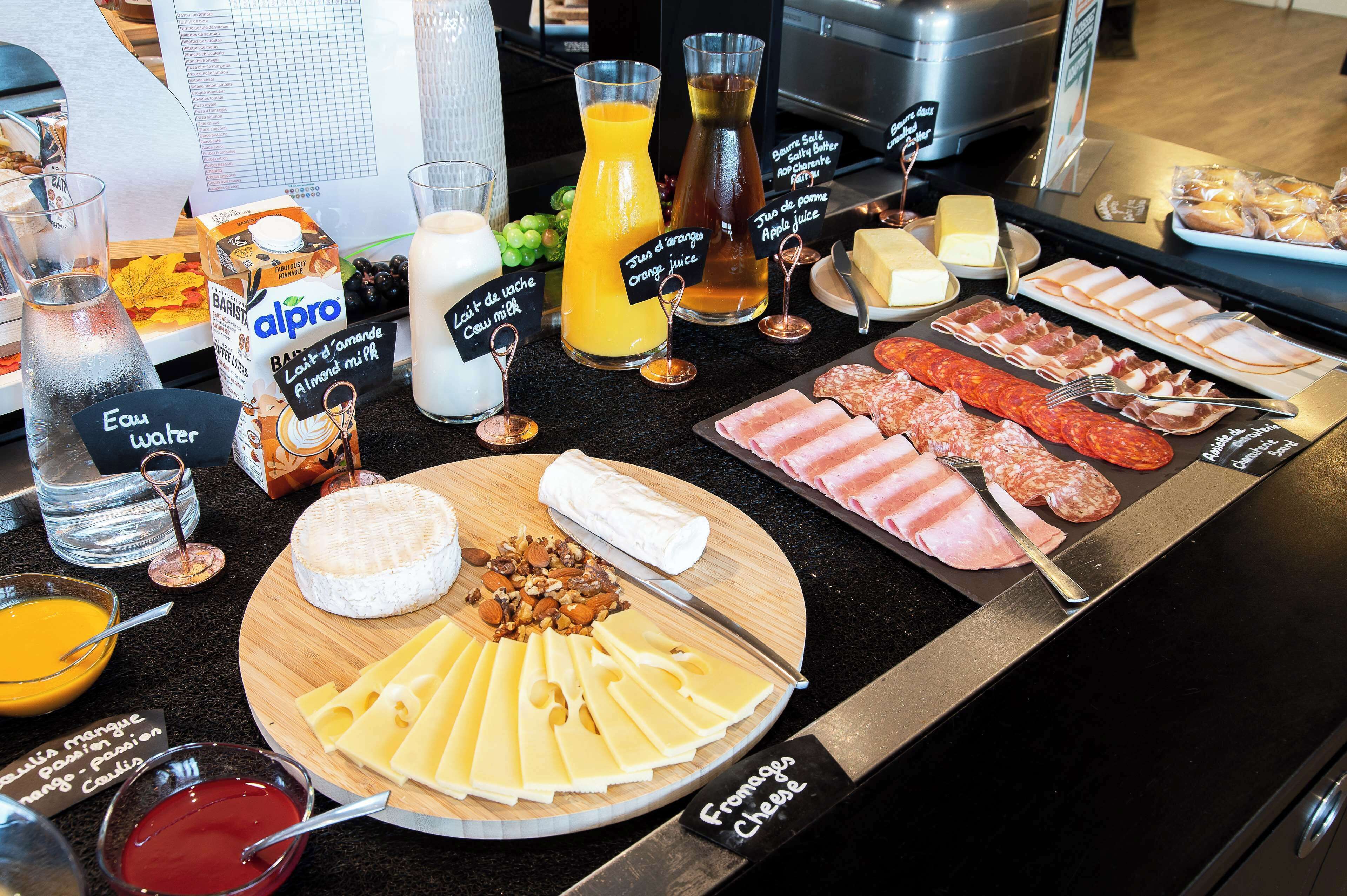 Un bufé con diversos quesos, carnes y bebidas.