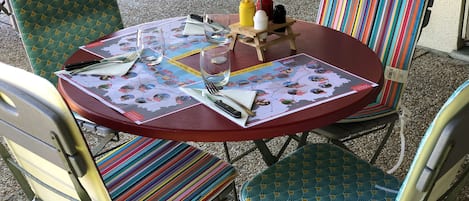 A round table with a map, a bottle of ketchup, a bottle of mustard, a bottle of water, and a small wooden table.