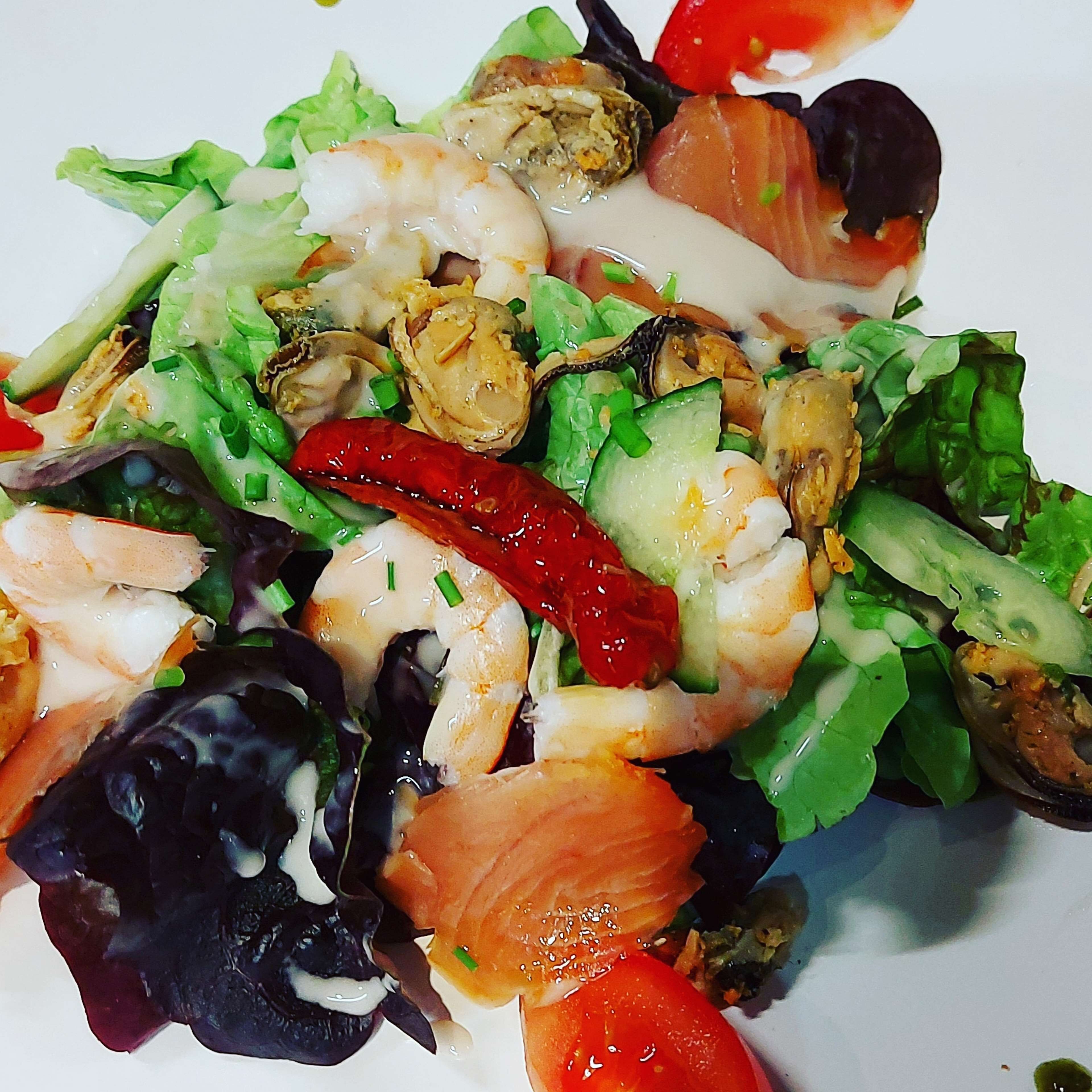 En sallad med räkor, tomater, gurka och bladgrönsaker.