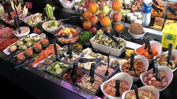 A buffet with various food items and utensils.