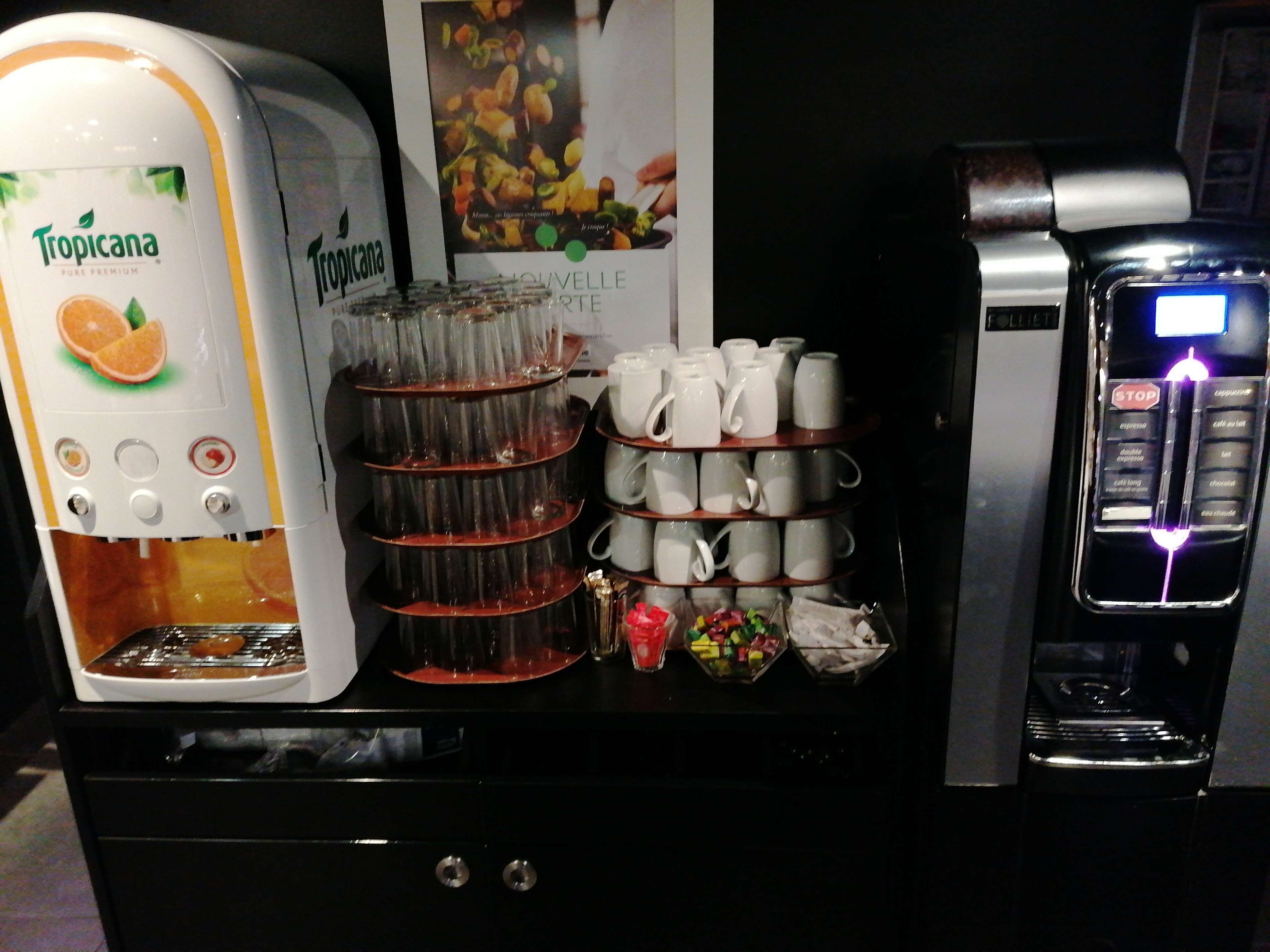 Une machine à café dotée d’un écran, d’un distributeur d’eau et d’un porte-tasses.