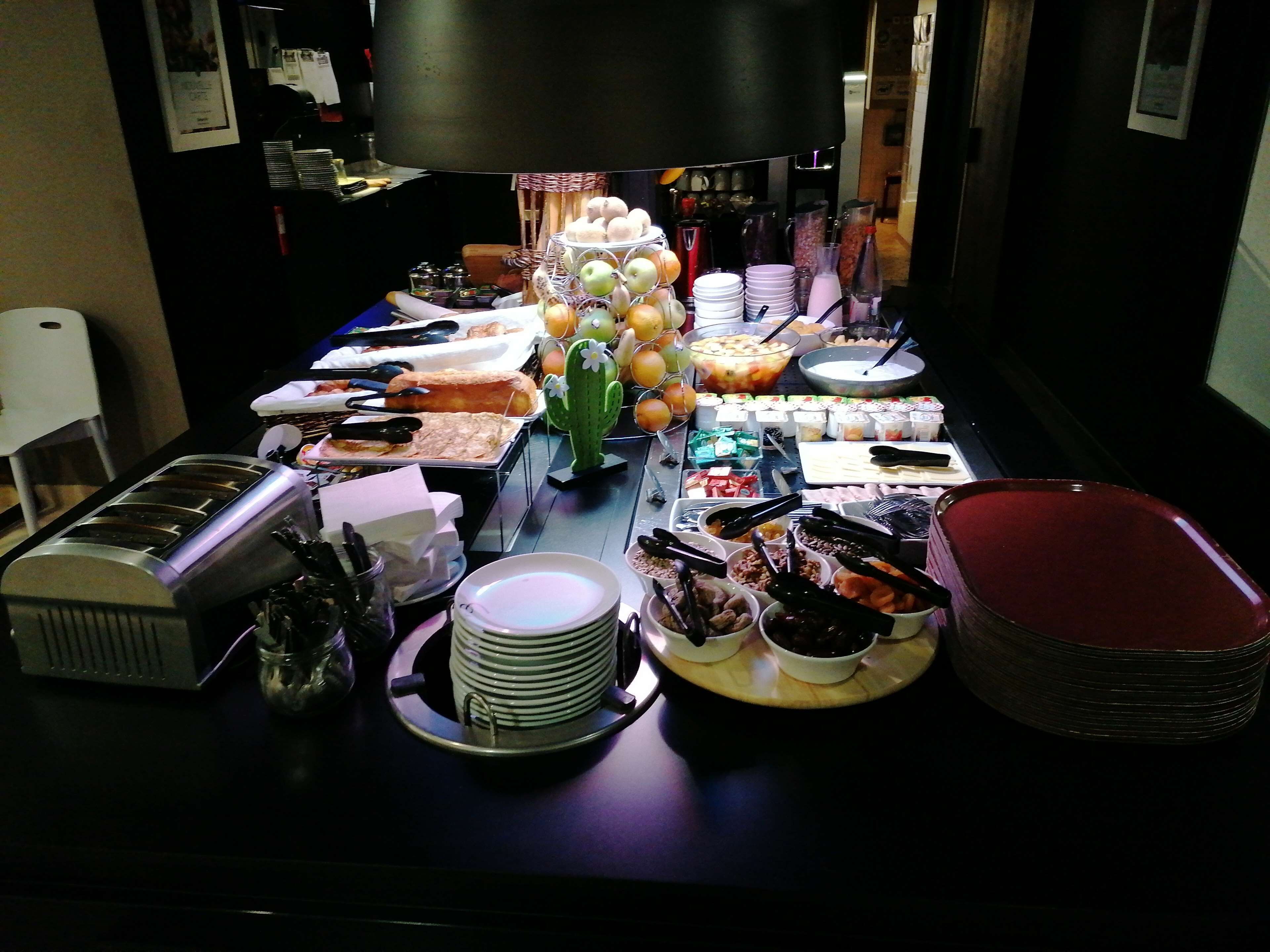 Una mesa de buffet con diversos alimentos y utensilios.