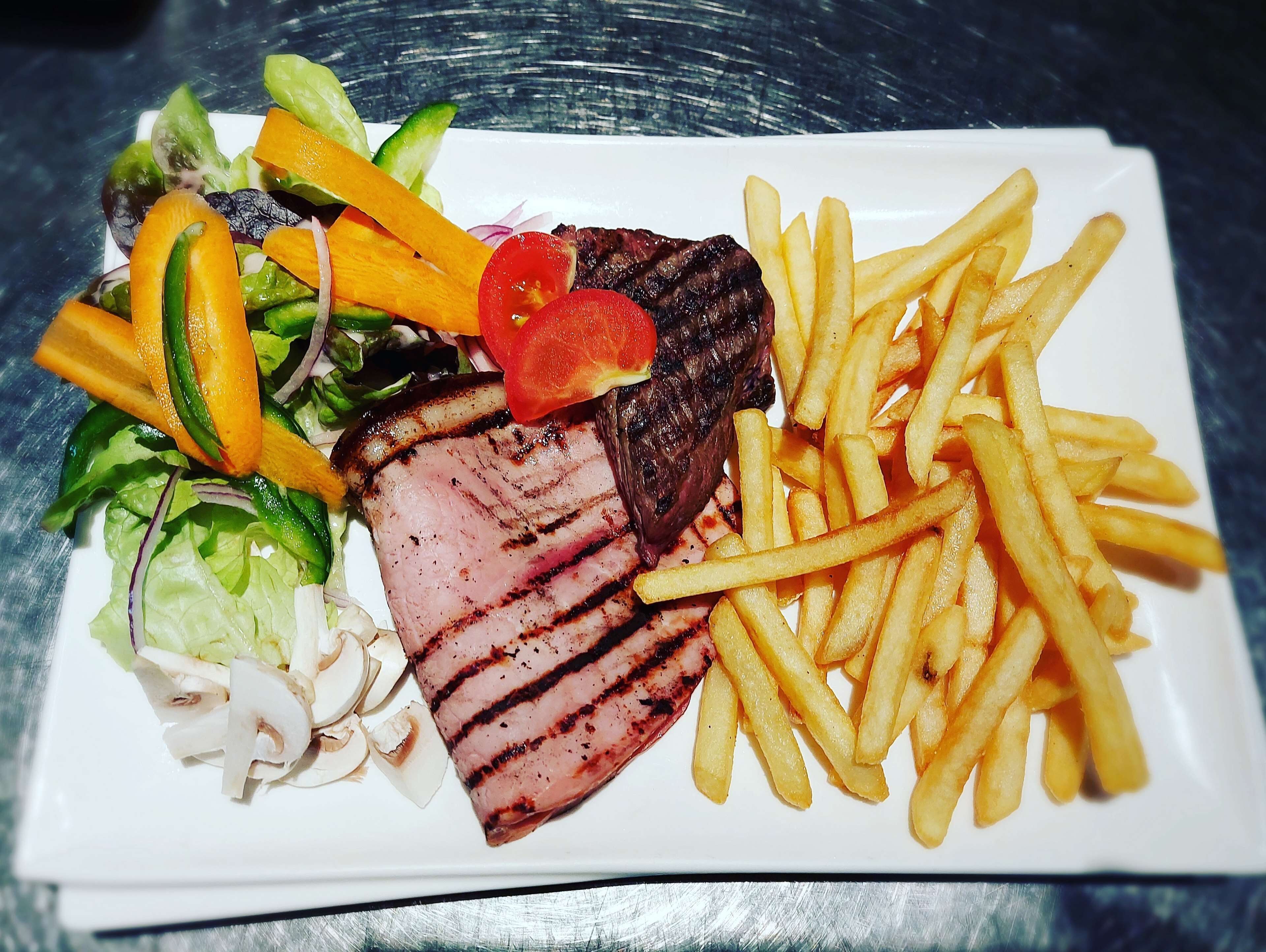 Prato com bife grelhado, batatas fritas e salada.