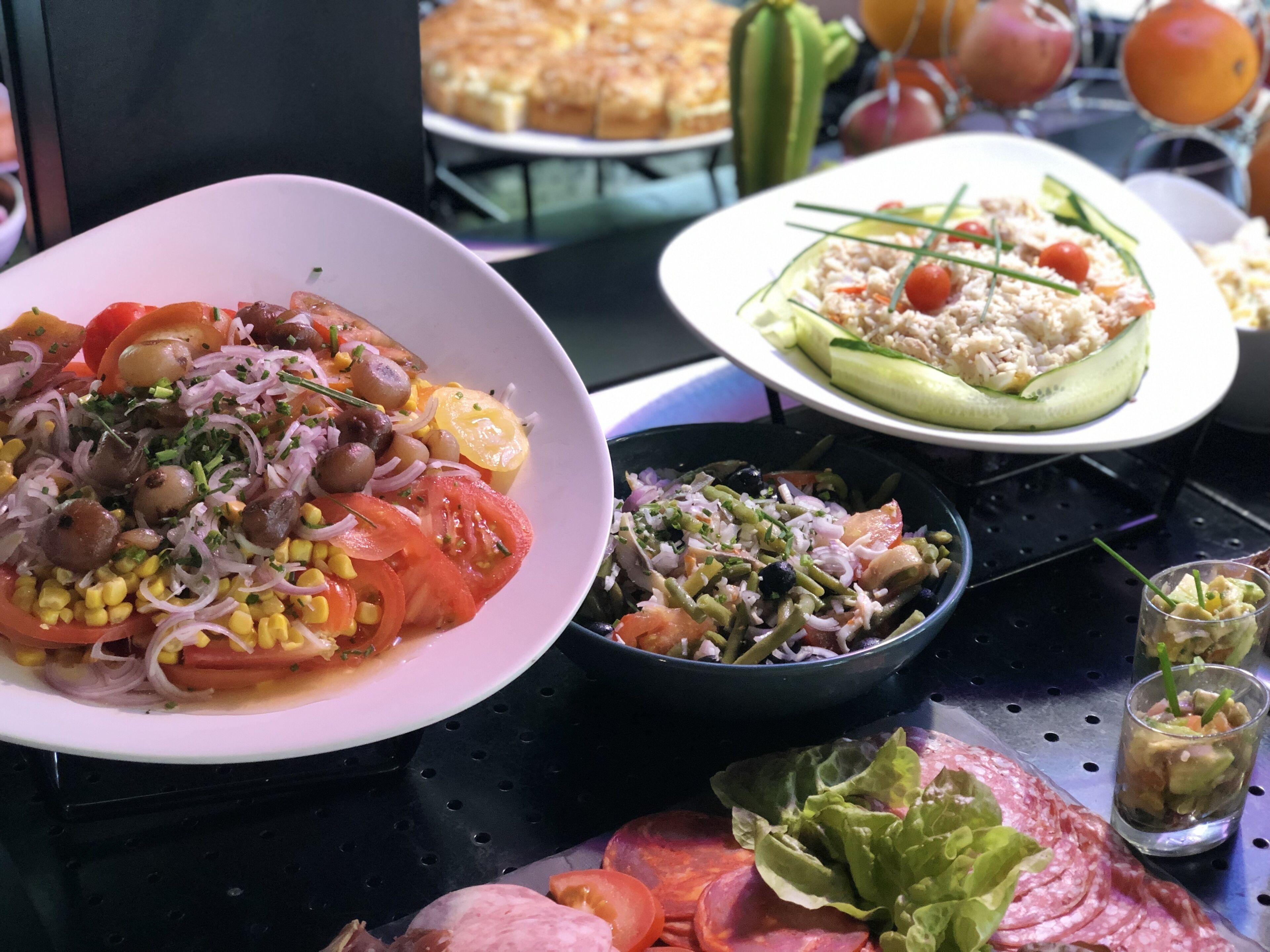 A table with various dishes including a salad, rice, and sliced meats.
