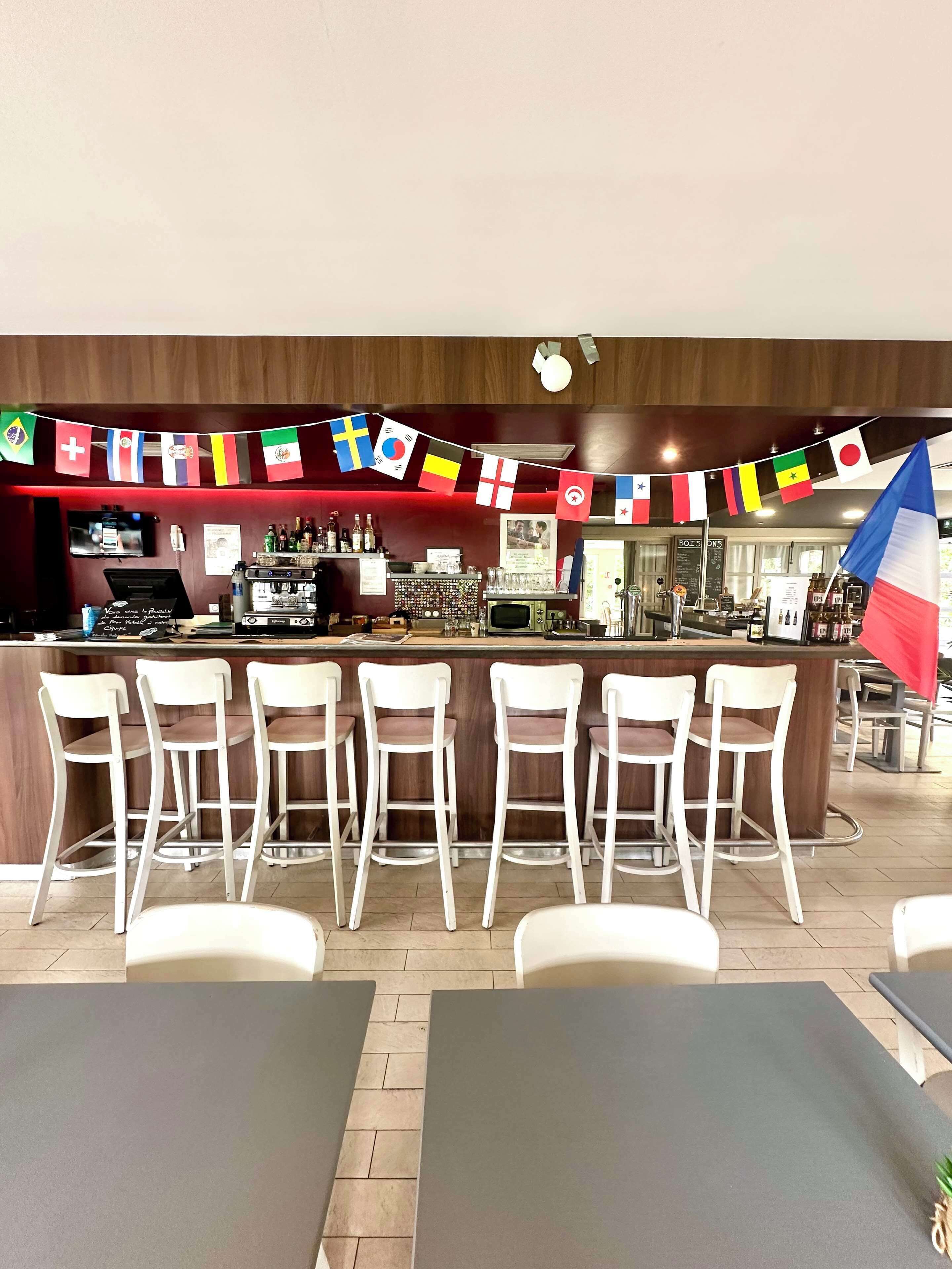 A bar area with a counter, bar stools, and a flag.