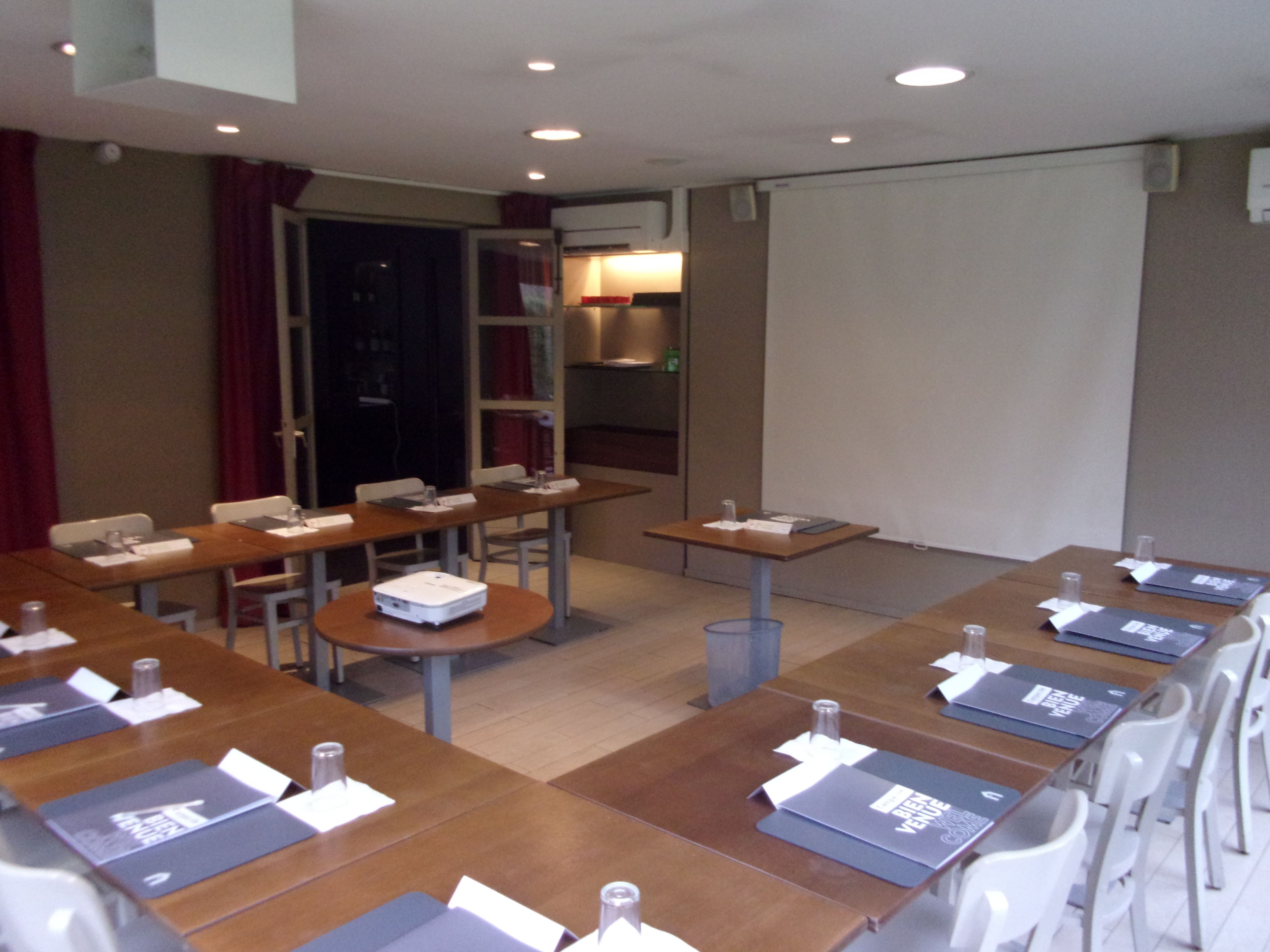 A conference room with tables, chairs, and presentation equipment.
