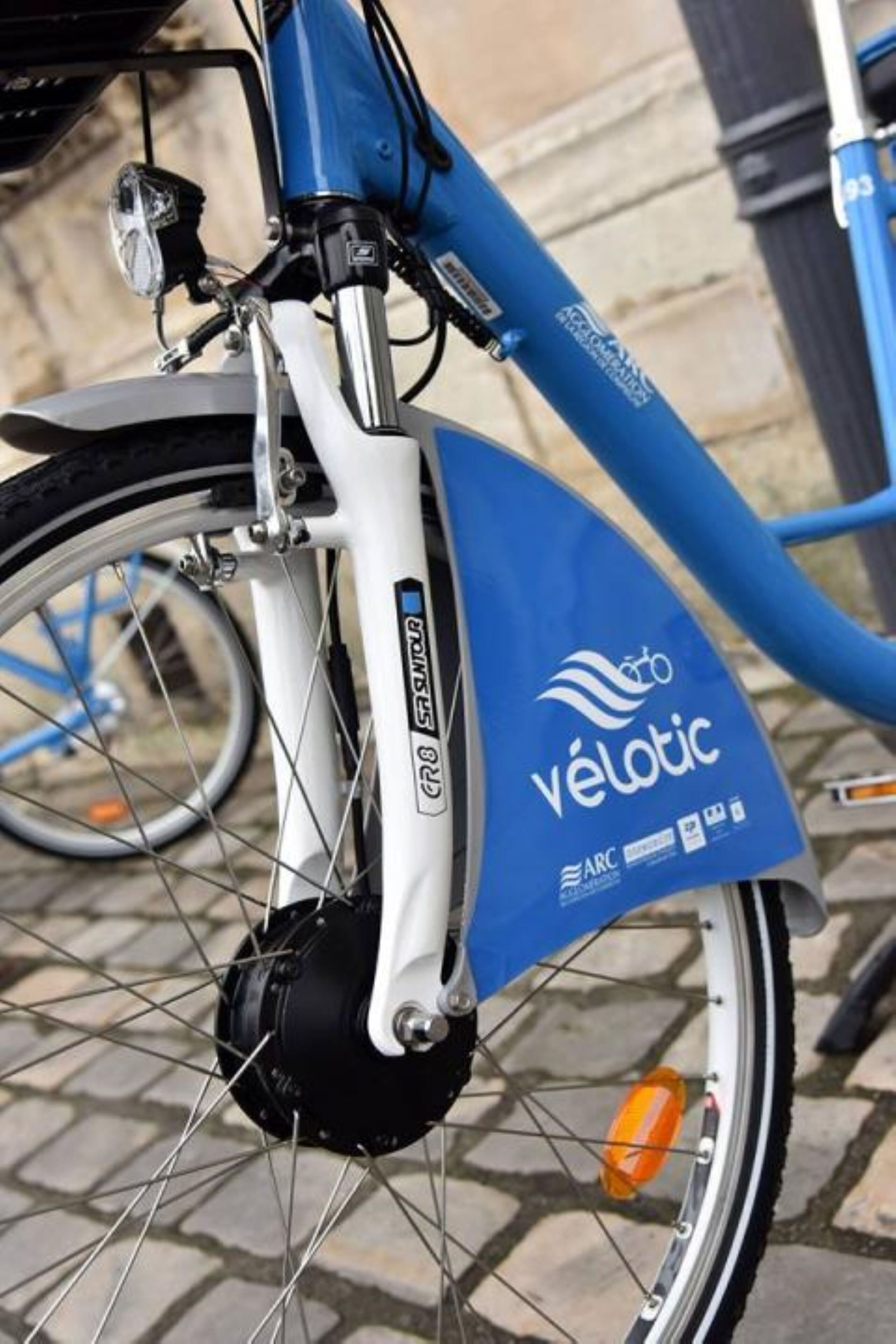 Primer plano de una bicicleta azul con el logotipo de VéloTic y certificación ARC.