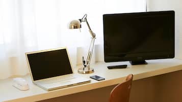 Escritorio, cortinas opacas, tabla de planchar con plancha