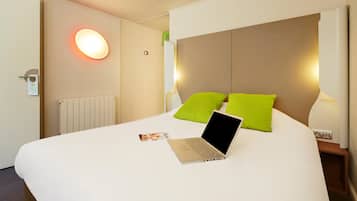 Escritorio, cortinas blackout y tabla de planchar con plancha