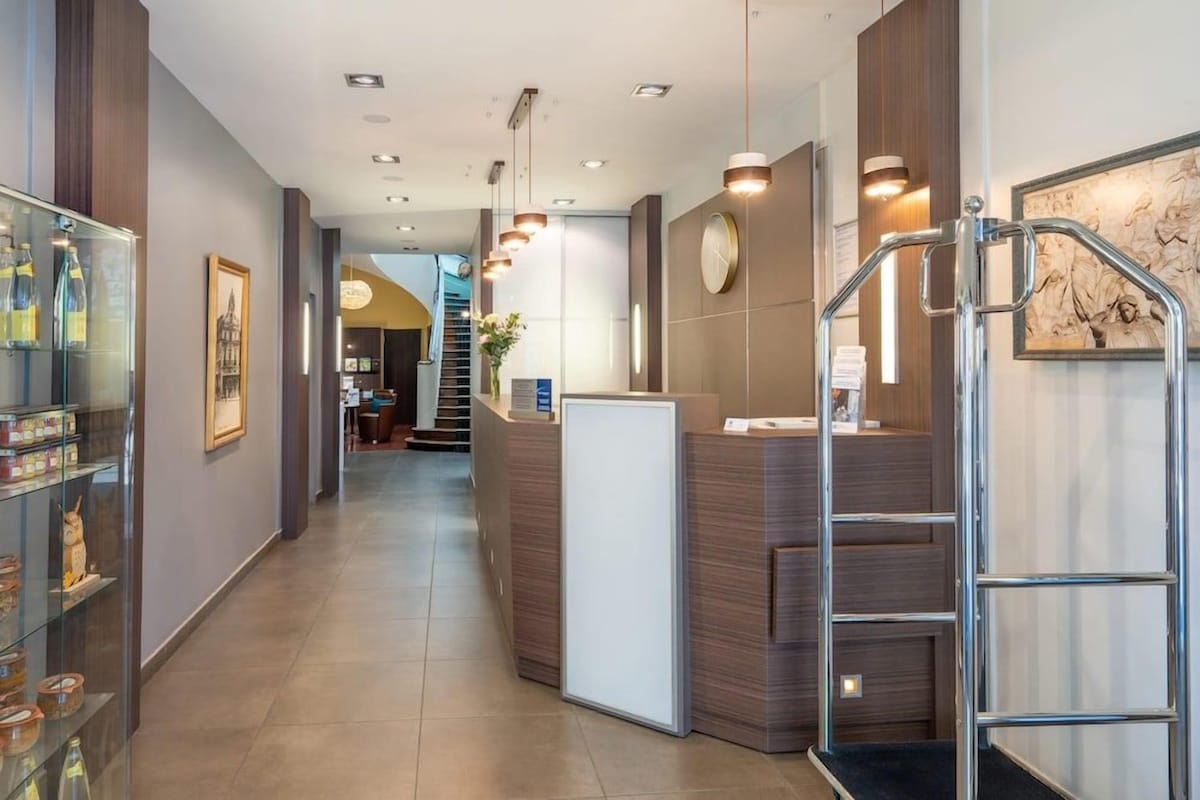 A reception area with a glass display case, a reception desk, and a staircase.