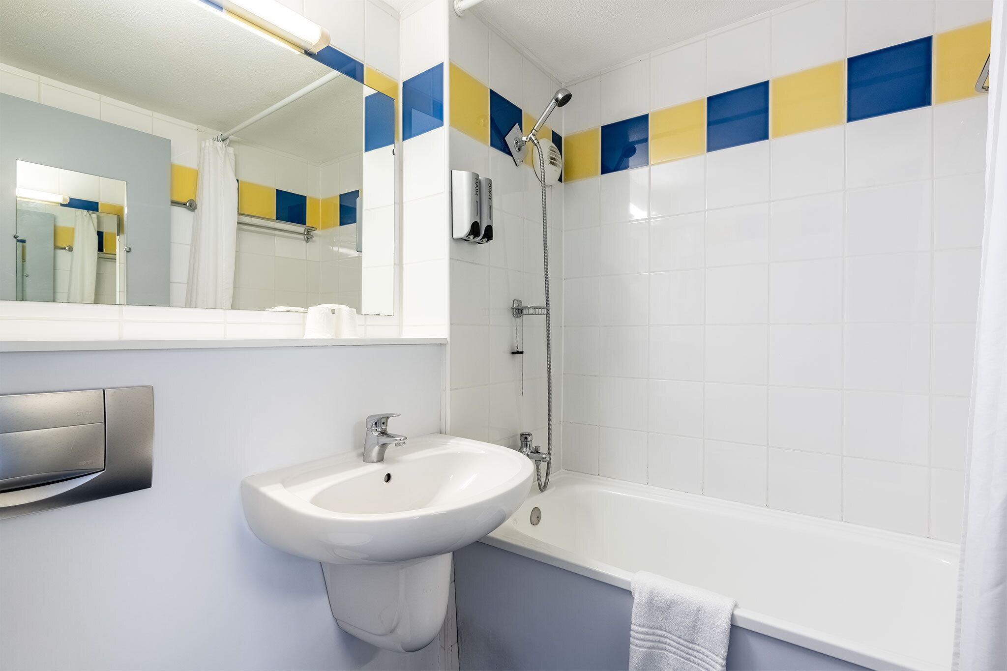 Un baño con lavamanos blanco, espejo, ducha y bañera.
