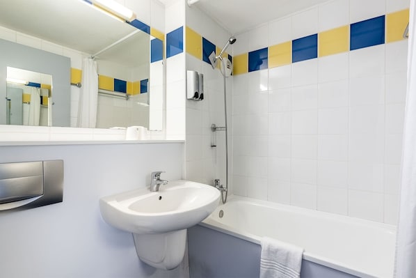 A bathroom with a white sink, a mirror, a shower, and a bathtub.