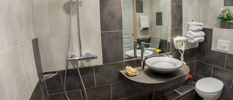 A modern bathroom with a shower, sink, and toilet.