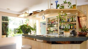 Une cuisine avec un coin bar, des meubles en bois, une fenêtre avec vue et une plante en pot.