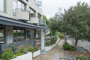 Un restaurante con terraza, una escalera y un árbol.