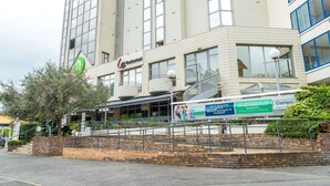 Un immeuble à plusieurs étages portant une enseigne indiquant qu’il s’agit d’un hôtel ou d’un établissement commercial.