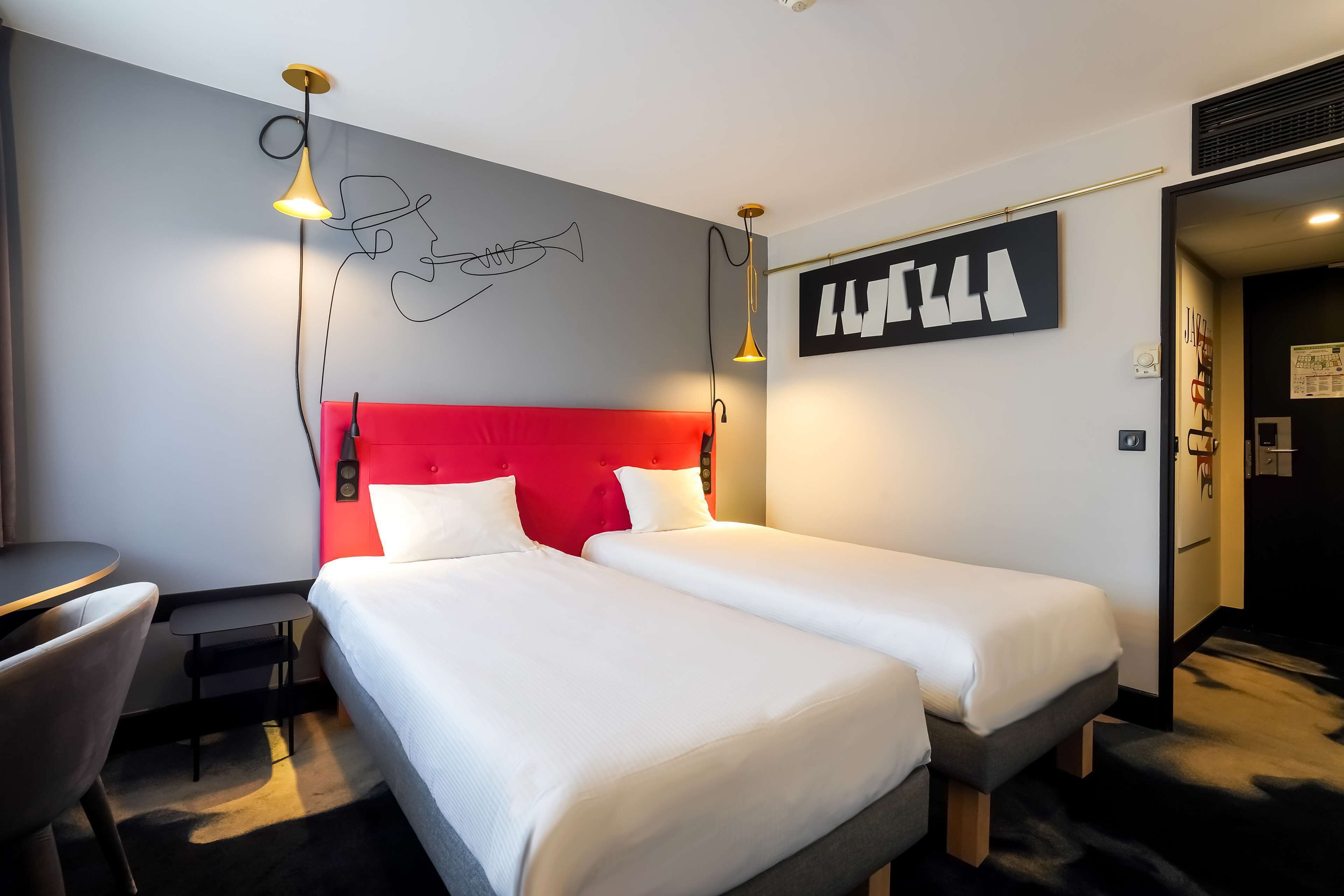 Une chambre d’hôtel avec deux lits, un bureau et une chaise.