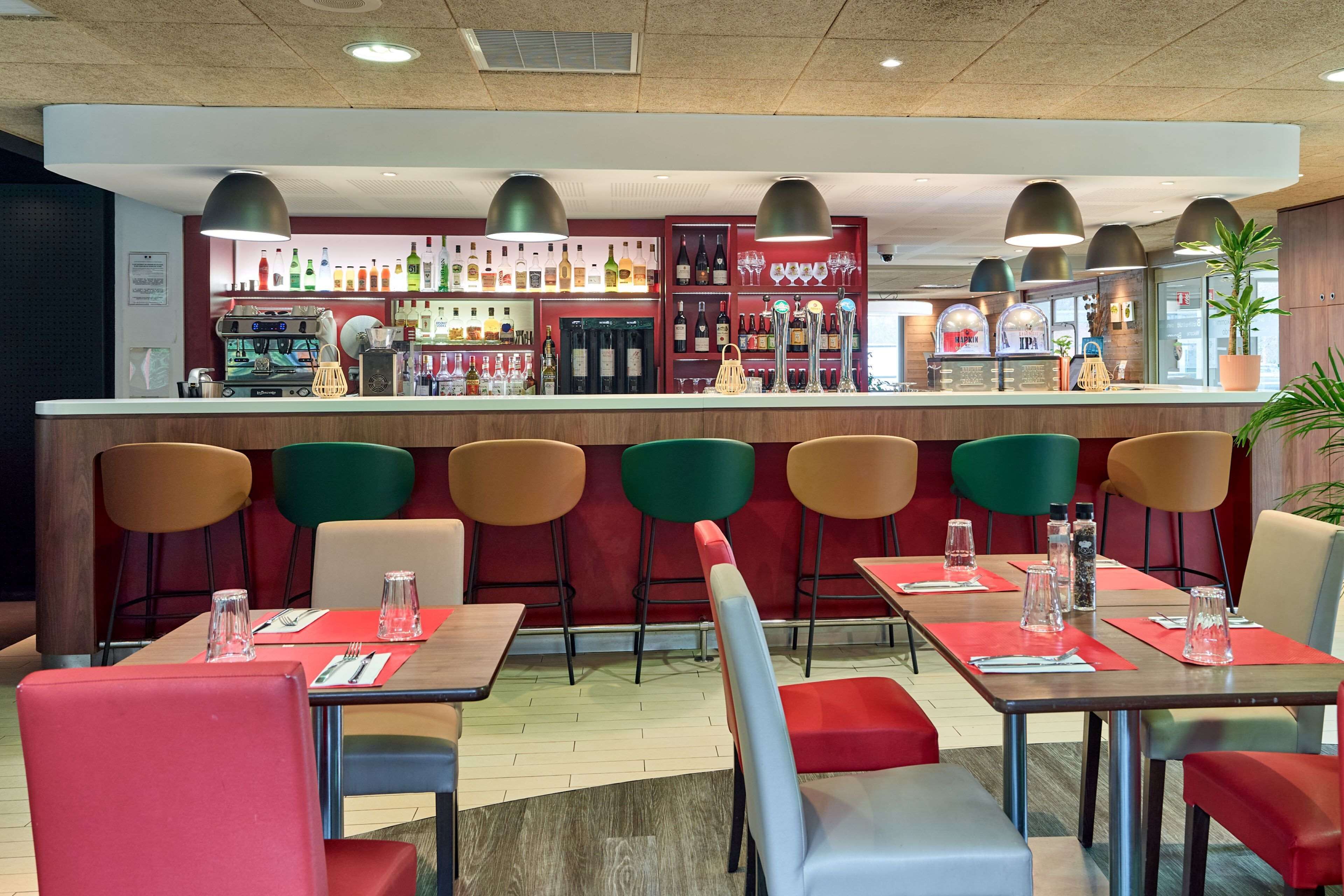 Un restaurant doté d'un bar, de chaises aux couleurs vives et de tables disposées avec soin.
