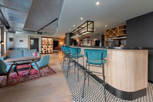 Un interior moderno con una zona de bar, asientos y cocina.
