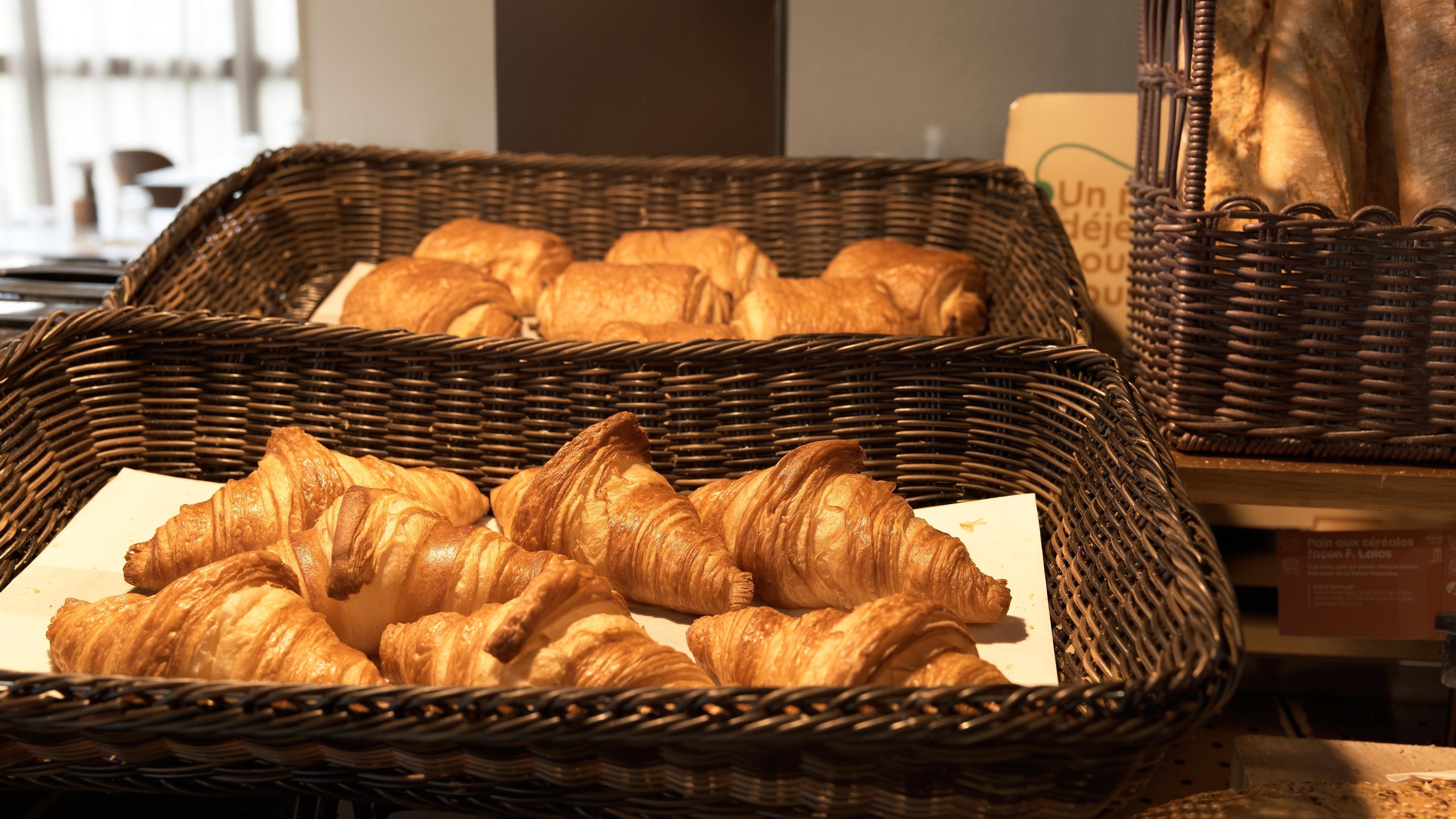 Wicker baskets filled with croissants on a table.