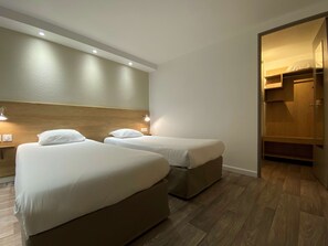 A hotel room with two beds, wooden headboard, recessed ceiling lights, and a wooden wardrobe. - Kyriad Fontenay Tresigny (Fontenay-Tresigny)