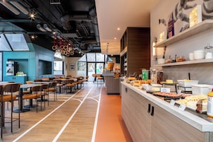 Un restaurante moderno con una barra alargada, varias zonas de estar y vistas al exterior.