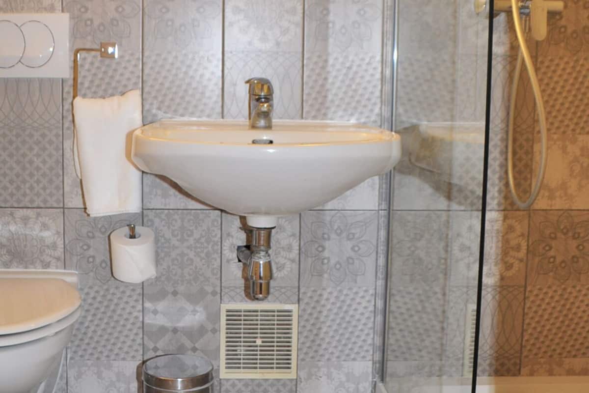 Um banheiro com pia, vaso sanitário e chuveiro.