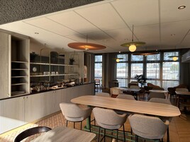 Un interior moderno con una zona de bar, asientos y ventanas amplias.