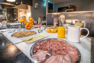 Una mesa de buffet con diversos alimentos y bebidas.