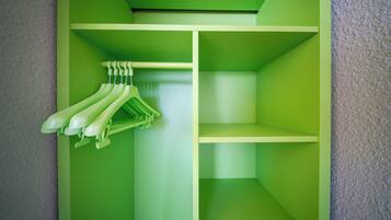 A green closet with hanging space for clothes and shelves.