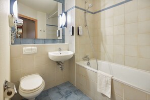 A bathroom with a toilet, sink, and bathtub. - Campanile - Poznan (Poznan)