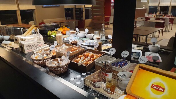 Un área de bufé con diversos alimentos y aderezos.
