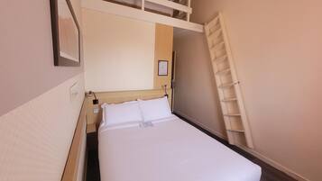 Une chambre à coucher avec un lit, une tête de lit, une étagère fixée au mur et une échelle.