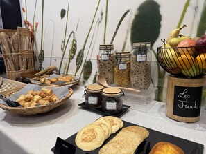 Un bufé de desayuno con cruasanes, panqueques y diversas mermeladas y pastas de frutos secos.